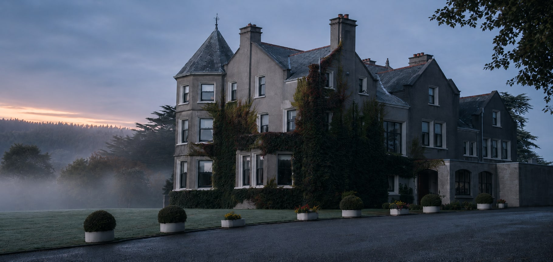Enniskeen Country House Hotel at dawn, mist across the valley behind its gabled façade, turret and ivy