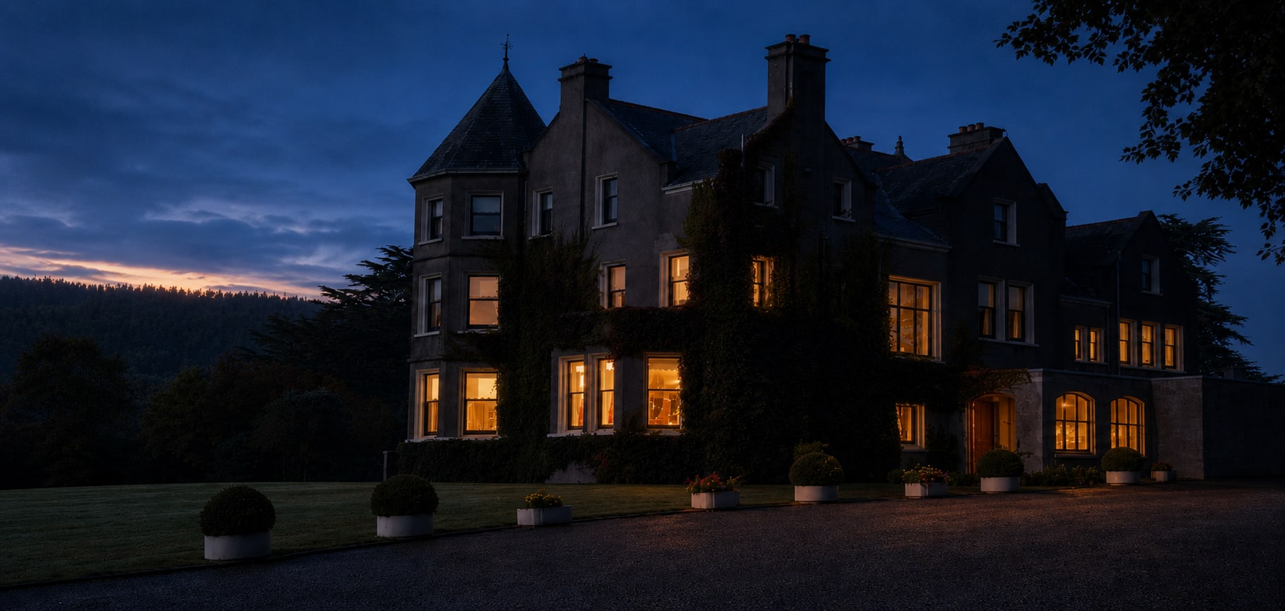 Enniskeen Country House Hotel at dusk, its windows lit against the darkening Shimna Valley