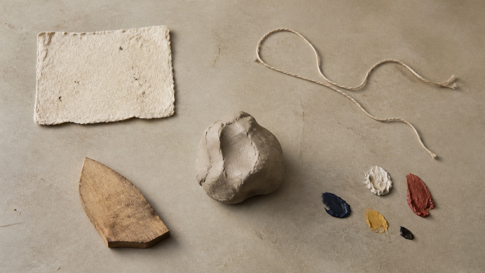 AI-generated original craft scene of paper, thread, clay, wood and paint sitting separately on a worktable
