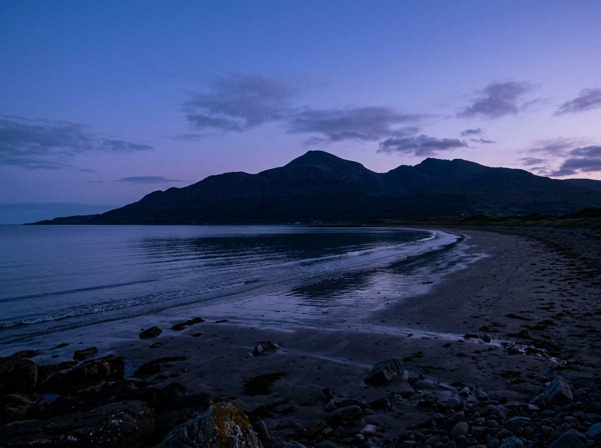 Quiet Newcastle shoreline and silhouette of Slieve Donard at peaceful twilight